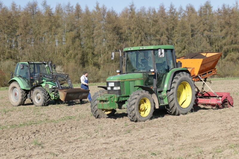 Ein John Deere bringt Kompost unter die Pflugsohle